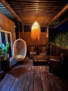 eine Veranda mit Schaukel und Kronleuchter in der Unterkunft Almarena, tu casa en Punta del Este in Manantiales