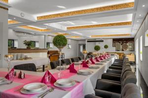 a long dining room with pink tables and chairs at Agroturystyka Kociołek in Kociołki