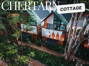 a house in the middle of a forest with the words butterfly cottage at Chertarn Homestay in Ban Pang Bo Hu Bon