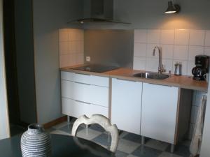 a kitchen with white cabinets and a sink and a table at La Roseraie, campagne, calme et paix in Bulson +8 photos