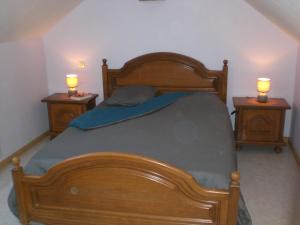 a bedroom with a wooden bed with two night stands at La Roseraie, campagne, calme et paix in Bulson