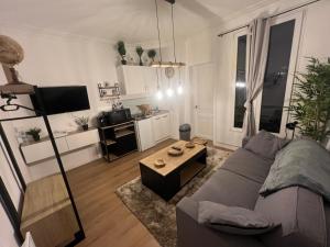 ein Wohnzimmer mit Sofa und Tisch in der Unterkunft Studio cosy aux portes de Paris - 2PAX in Saint-Ouen + 2 Fotos