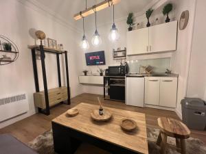 ein Wohnzimmer mit Tisch und Küche in der Unterkunft Studio cosy aux portes de Paris - 2PAX in Saint-Ouen