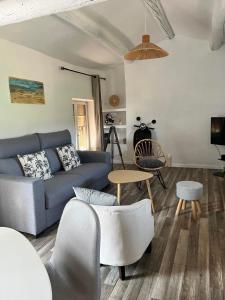 a living room with a blue couch and a table at Appartement st Victor in Puyvert