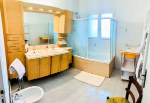 a bathroom with two sinks and a shower at Le Balcon bleu de Biscarrosse in Biscarrosse +12 photos