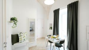 a white dining room with a table and chairs at Dimora del Tenente in Locorotondo