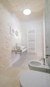 a white bathroom with a tub and a sink at Dimora del Tenente in Locorotondo