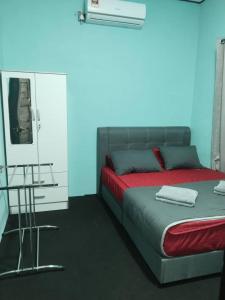 a bedroom with a bed with a blue background at Nour homestay Rumah B in Kaki Bukit