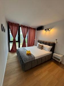 a bedroom with a large bed with red curtains at Casa en Sol - 5 min walk to Therme Balotesti in Baloteşti