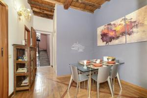 Un comedor con una mesa de cristal y sillas. en PANTHEON 2 - LARGE APARTMENT IN THE HEARTH OF ROME a, en Roma