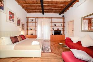 sala de estar con cama blanca y sofá rojo en PANTHEON 2 - LARGE APARTMENT IN THE HEARTH OF ROME a, en Roma