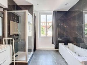 ヴィルールバンヌにあるMy home jean claude vivant 1の浴槽とシャワー付きの広いバスルーム