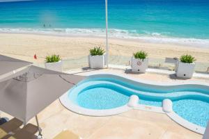 a swimming pool with the beach in the background at New studio at the Beach, pool, gym, spa 2D in Cancún