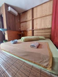 a large bed in a room with wooden walls at Nuttonton Homes in Papas