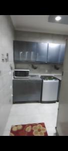 a kitchen with a stove and cabinets and a rug at شقة فندقية للايجار in Nazlat as Sammān +9 photos