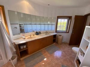 a bathroom with two sinks and a large mirror at Amazigh Guincho Hostel & Suítes in Cascais +37 photos