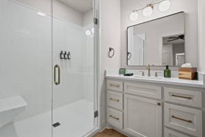 ein Badezimmer mit Dusche, Waschbecken und Spiegel in der Unterkunft Lake Ouachita's Luxury Lake House in Mount Ida + 28 Fotos