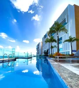 a hotel swimming pool with palm trees and a building at Apartamento Marina Vip in Salvador