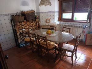 a dining room with a table and chairs and a pile of logs at Casa Fatinha in Amarante +13 photos