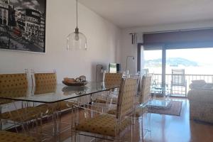 a dining room with a glass table and chairs at Casa Fatinha in Amarante