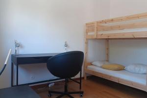 a desk and a chair in a room with a bunk bed at Casa Fatinha in Amarante
