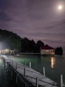 a dock with a house on the water at night at Nuttonton Homes in Papas +3 photos