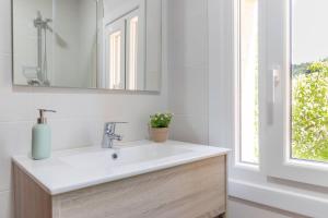 a bathroom with a sink and a mirror and a window at El Balcón de Préjano in Préjano +22 photos