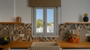 a kitchen with a sink and a window at Marvarit Villas in Vóthon