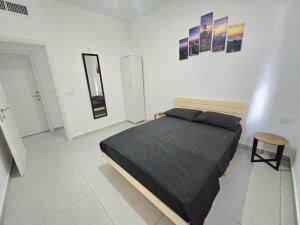 a bedroom with a bed in a white room at EilatCasa in Eilat