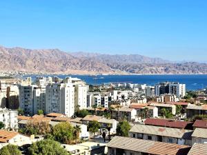 a city with buildings and the water and mountains at EilatCasa in Eilat