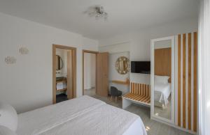 a white bedroom with a bed and a mirror at Marvarit Villas in Vóthon +48 photos