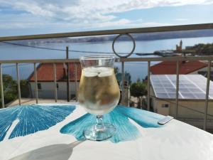 a glass of water sitting on a table with an umbrella at Apartmans Martha in Karlobag