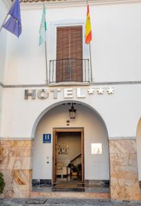 a hotel with flags on top of a building at Hotel Don Miguel Plaza in Berja