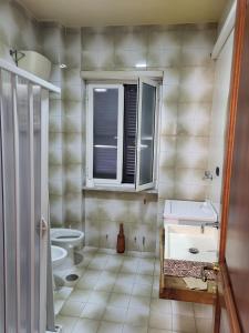 a bathroom with a sink and a toilet at Appartamento Fotia in Giugliano in Campania +19 photos