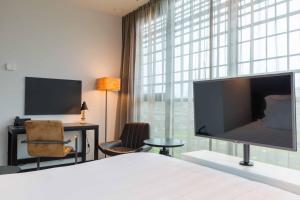 TV a/nebo společenská místnost v ubytování Leonardo Hotel Groningen