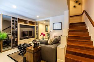 ein Wohnzimmer mit Treppe und Couch in der Unterkunft Sukhumvit 16 Townhouses, InHome Luxury Residences in Bangkok