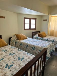 Un dormitorio con dos camas y una ventana. en BahiaCaracoles Apart, en Antofagasta