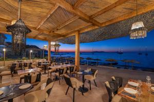 a restaurant with tables and chairs and a view of the ocean at Silver Beach Hotel in Kardamaina