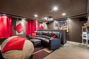 a theater room with a leather couch and a bed at Sleeps 10, Indoor and Outdoor Theaters, Batting Cage, & Games! in Westfield