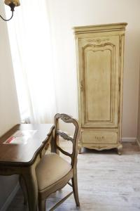 シャルトルにあるThe Originals Boutique, Hôtel Les Poèmes de Chartresのデスク、椅子、ドレッサーが備わる客室です。