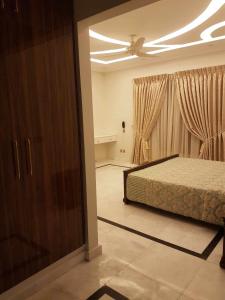 a bedroom with a bed and a ceiling at Royal Palace Hotel in Islamabad