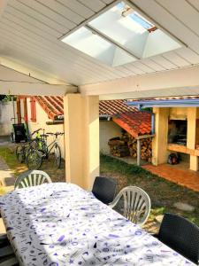 a table and chairs under a roof with a fire place at Le Balcon bleu de Biscarrosse in Biscarrosse