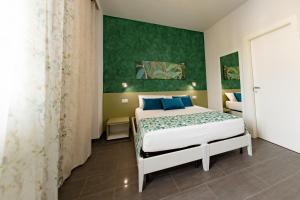 a bedroom with a bed and a green wall at Celeste Affittacamere in Cefalù