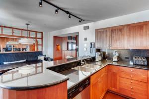 a kitchen with wooden cabinets and stainless steel appliances at Village Hall 12 by East West Hospitality in Beaver Creek
