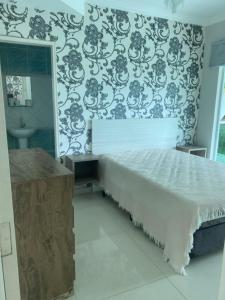 a bedroom with a bed and a sink and a mirror at Casa de Praia em Condomínio Hanga Roa Bertioga in Riviera de São Lourenço +20 photos