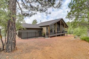 una casa con un porche y un árbol en Luxe Pine Home with Tonto National Forest Access!, en Pine