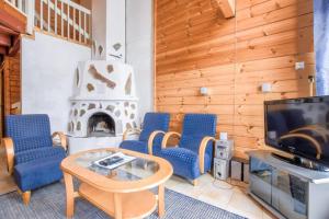 a living room with blue chairs and a tv and a fireplace at VIP-Tahko 4 in Tahkovuori