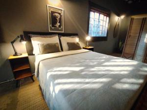 a bedroom with a large bed and a window at Loft Industrial in Santo André