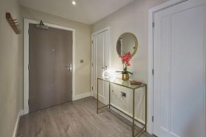 a hallway with a mirror and a dresser with a vase of flowers at Host & Stay - The Hideaway in York