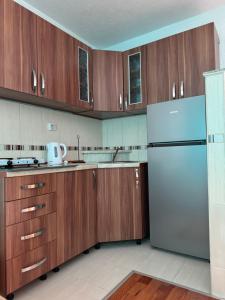 a kitchen with wooden cabinets and a refrigerator at Amaya Home Sarajevo in Vogošća